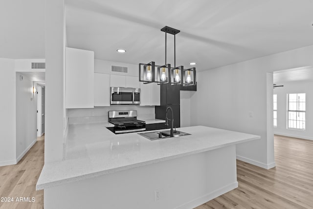 kitchen featuring light wood finished floors, a sink, visible vents, white cabinetry, and appliances with stainless steel finishes