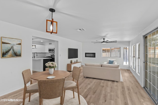 dining area featuring ceiling fan, visible vents, light wood-type flooring, and baseboards