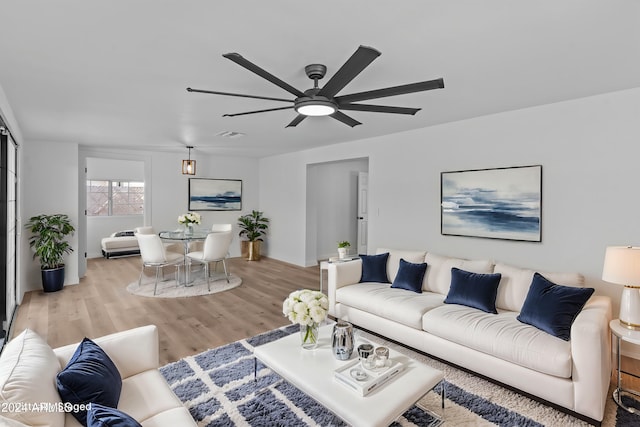 living area with light wood finished floors, ceiling fan, and visible vents