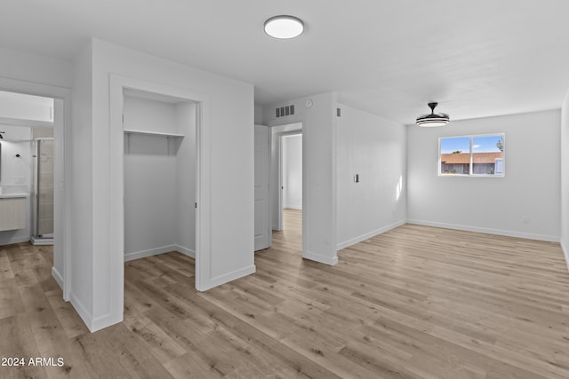 unfurnished bedroom featuring visible vents, light wood-style floors, a closet, baseboards, and a spacious closet