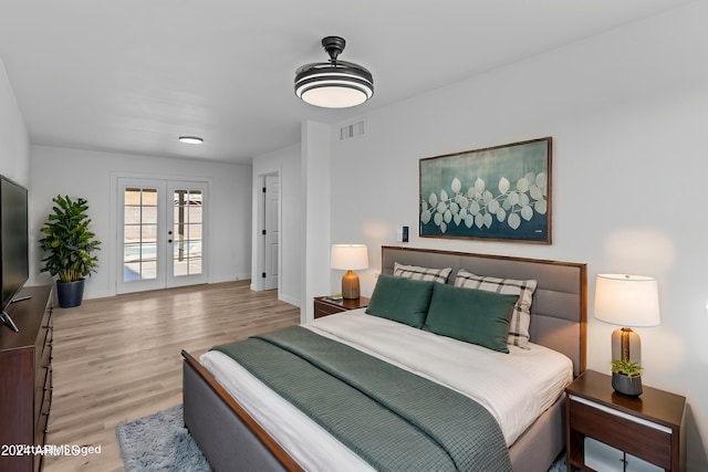 bedroom with visible vents, wood finished floors, access to outside, and french doors