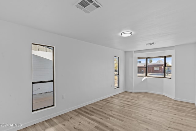 spare room with visible vents, light wood-style flooring, and baseboards