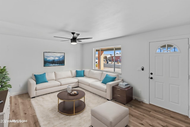 living room with a healthy amount of sunlight, ceiling fan, light wood-style flooring, and baseboards