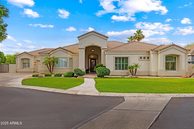 2625 N 24th St Unit 22, Mesa, AZ 85213 - mediterranean / spanish-style house with stucco siding, a tiled roof, driveway, and a front yard