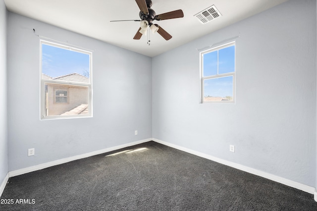 unfurnished room with a wealth of natural light, visible vents, and baseboards