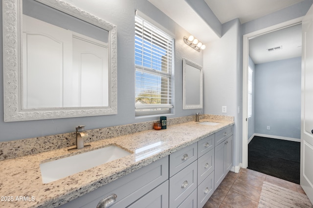 bathroom featuring double vanity, a sink, visible vents, and tile patterned floors