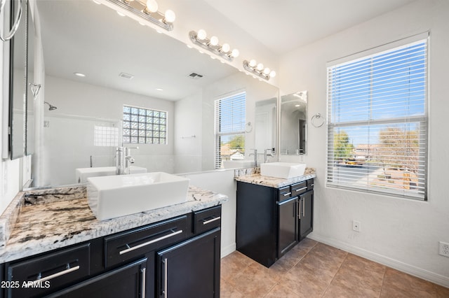 bathroom featuring two vanities, a sink, and visible vents