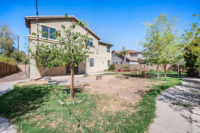 back of property featuring a tile roof, fence, and stucco siding