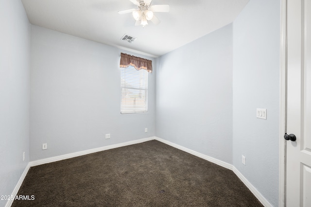 spare room featuring a ceiling fan, visible vents, dark carpet, and baseboards