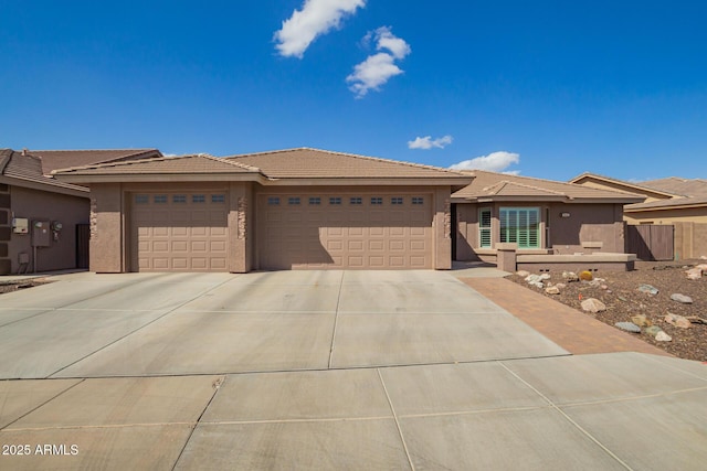 prairie-style house featuring concrete driveway, an attached garage, and stucco siding