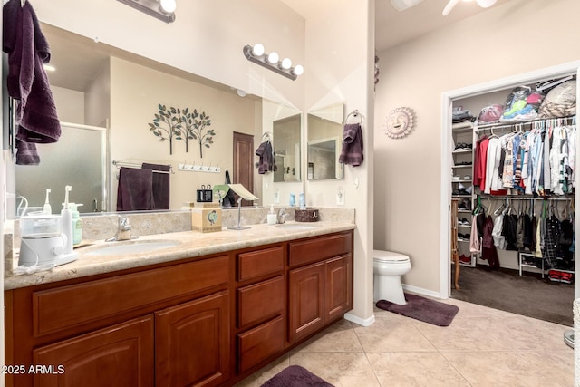 full bath featuring double vanity, tile patterned flooring, a sink, and a shower stall