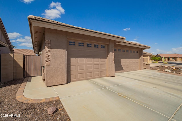 garage featuring driveway and a gate