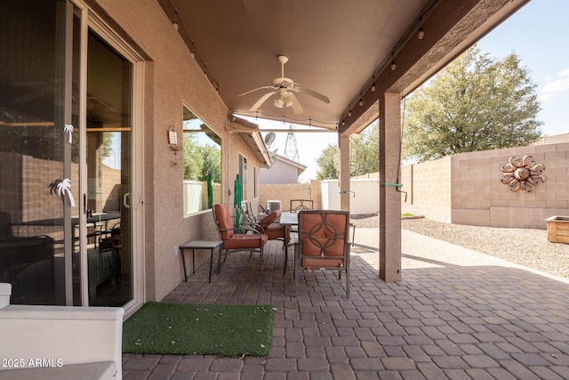 view of patio with a ceiling fan, outdoor dining area, and a fenced backyard