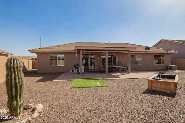 back of house featuring a patio, a fenced backyard, and stucco siding