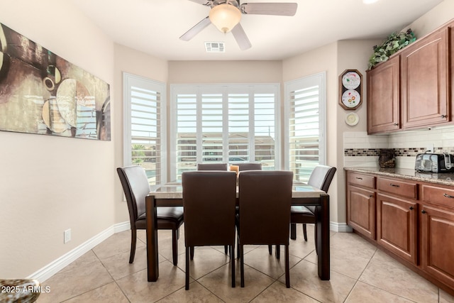 dining area with a ceiling fan, light tile patterned flooring, visible vents, and baseboards