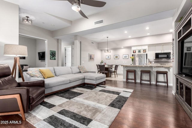 living room featuring ceiling fan, dark hardwood / wood-style flooring, and sink