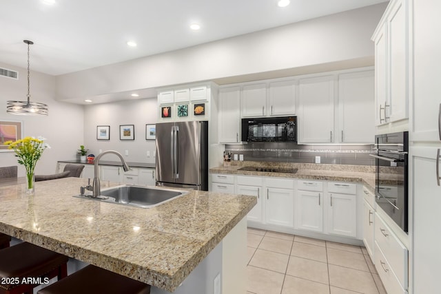 kitchen featuring sink, black appliances, an island with sink, and white cabinets