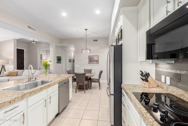 kitchen with pendant lighting, white cabinetry, sink, light tile patterned floors, and black appliances