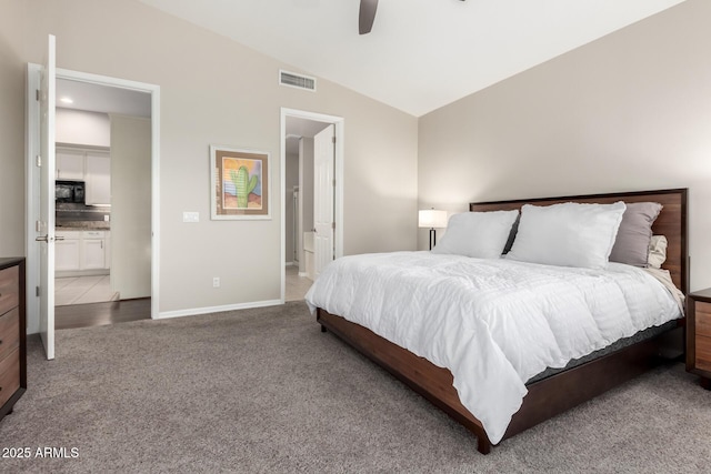 bedroom with lofted ceiling, connected bathroom, ceiling fan, and carpet