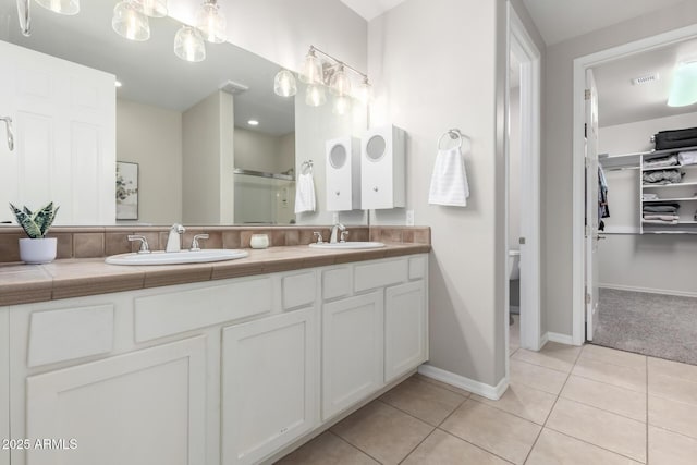 bathroom with vanity, a shower with shower door, and tile patterned floors