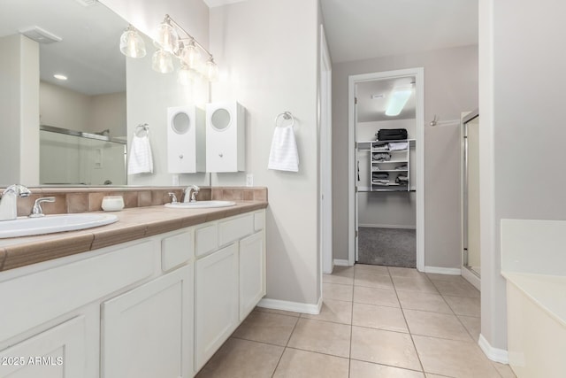 bathroom featuring tile patterned flooring, vanity, and walk in shower