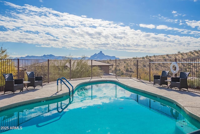 view of swimming pool with a mountain view and a patio area