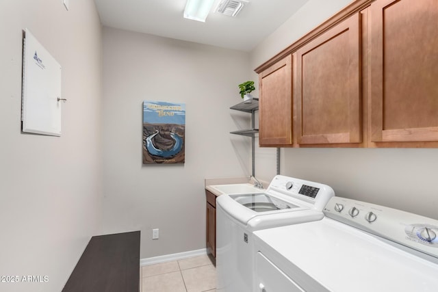 clothes washing area with cabinets, light tile patterned flooring, sink, and independent washer and dryer