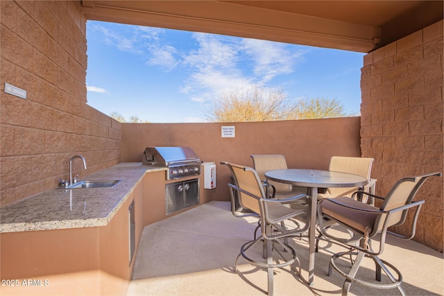 view of patio / terrace with area for grilling, a grill, and sink