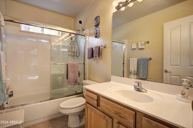 full bathroom featuring combined bath / shower with glass door, vanity, toilet, and tile patterned flooring