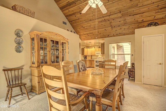 dining room featuring ceiling fan, wood ceiling, light carpet, and high vaulted ceiling