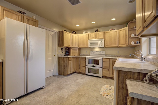 kitchen with sink, light tile patterned floors, white appliances, and light brown cabinets