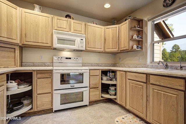 kitchen with white appliances, sink, light brown cabinets, light tile patterned floors, and lofted ceiling