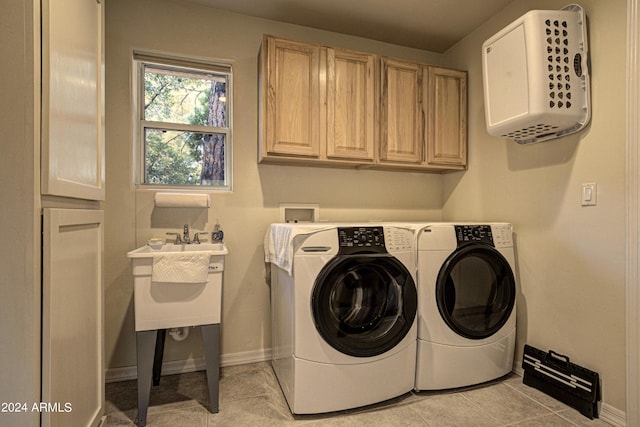 washroom with cabinets, washer and dryer, and light tile patterned flooring