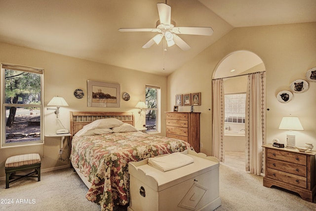 bedroom featuring connected bathroom, ceiling fan, light carpet, and lofted ceiling