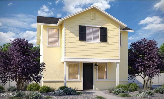 view of front facade with fence and stucco siding