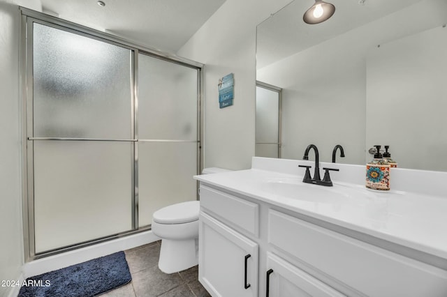 bathroom with tile patterned flooring, vanity, an enclosed shower, and toilet