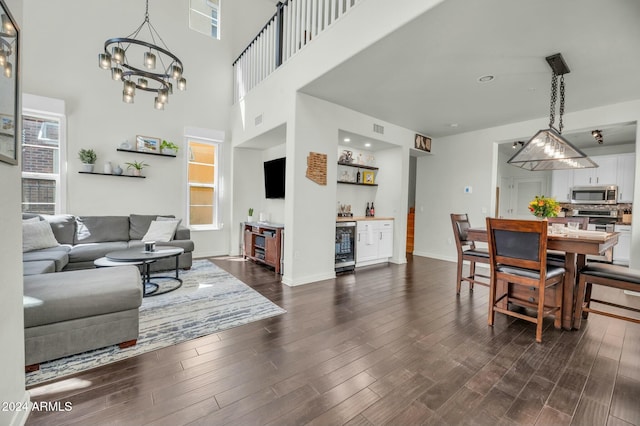 living room with dark hardwood / wood-style floors, plenty of natural light, wine cooler, and a chandelier