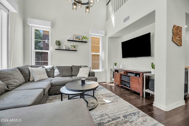 living room with dark hardwood / wood-style flooring, a high ceiling, and a chandelier