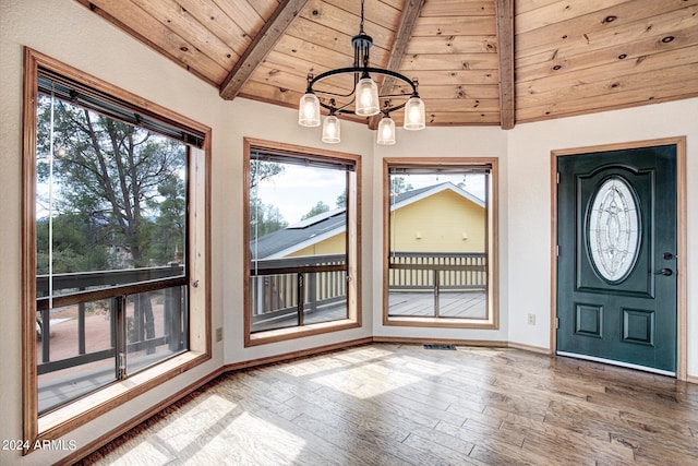 foyer entrance with wood ceiling, an inviting chandelier, lofted ceiling with beams, and hardwood / wood-style floors