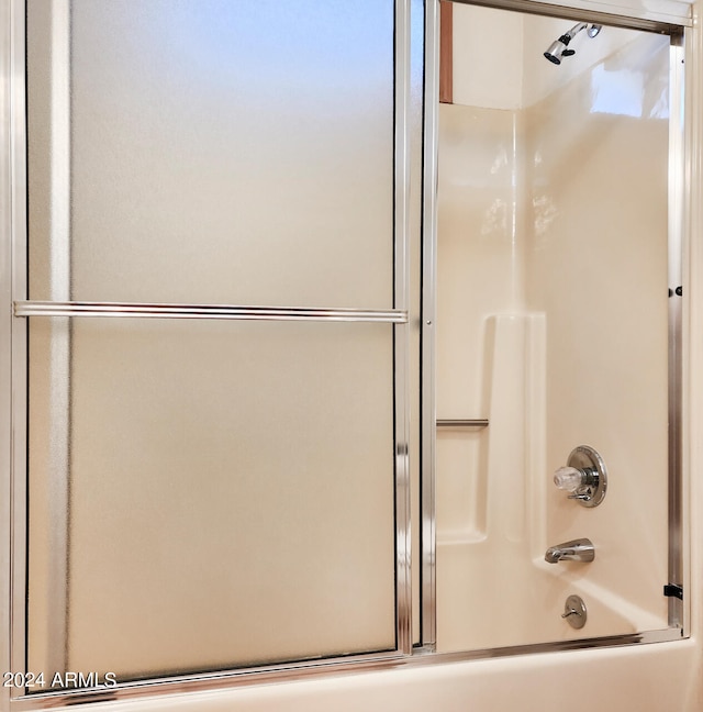 bathroom with shower / bath combination with glass door