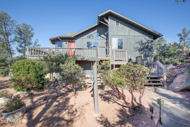 rear view of property featuring a wooden deck