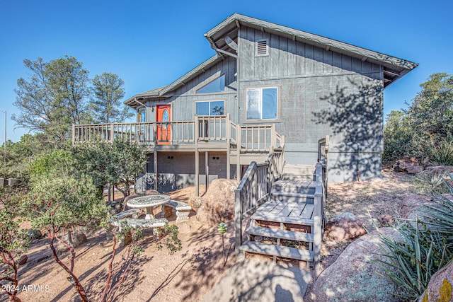 back of house featuring a wooden deck and a fire pit