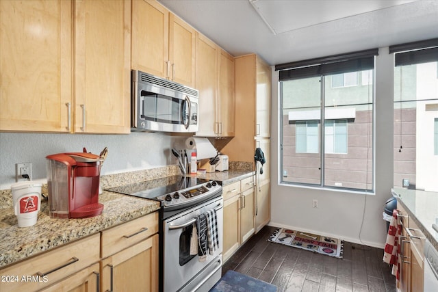 kitchen featuring dark hardwood / wood-style flooring, light brown cabinetry, appliances with stainless steel finishes, and light stone countertops