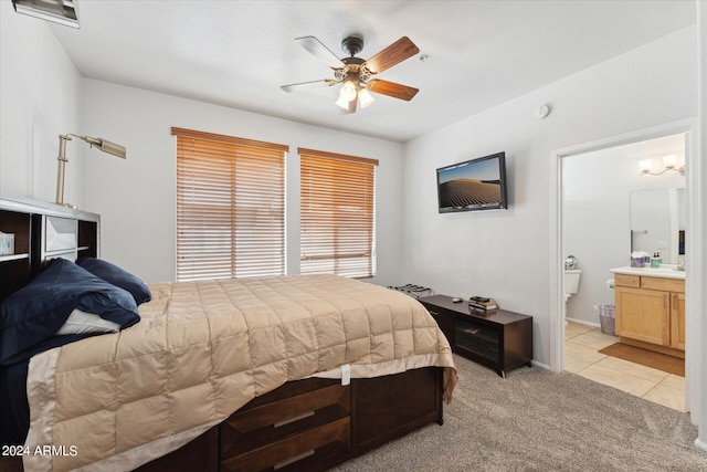 carpeted bedroom with ceiling fan and ensuite bath