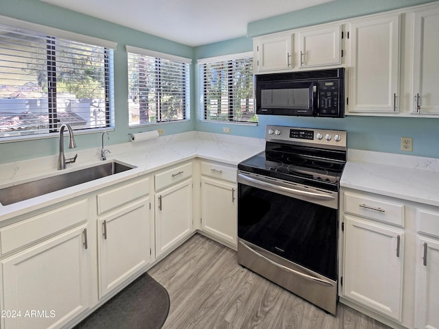 kitchen featuring white cabinets, stainless steel electric range, light wood-type flooring, black microwave, and a sink