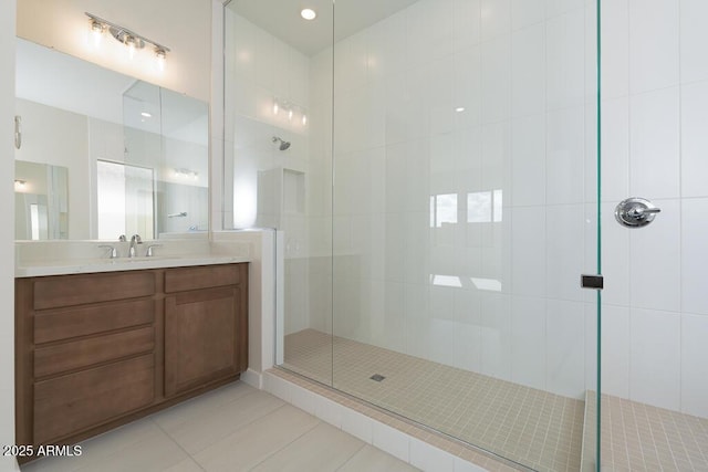 bathroom featuring tile patterned floors, a shower with shower door, and vanity