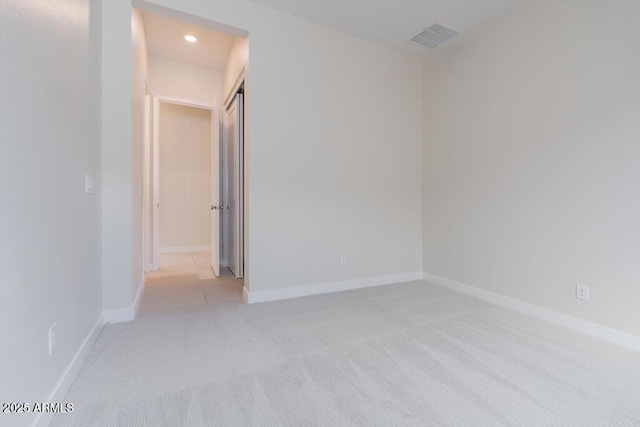 unfurnished room featuring light carpet