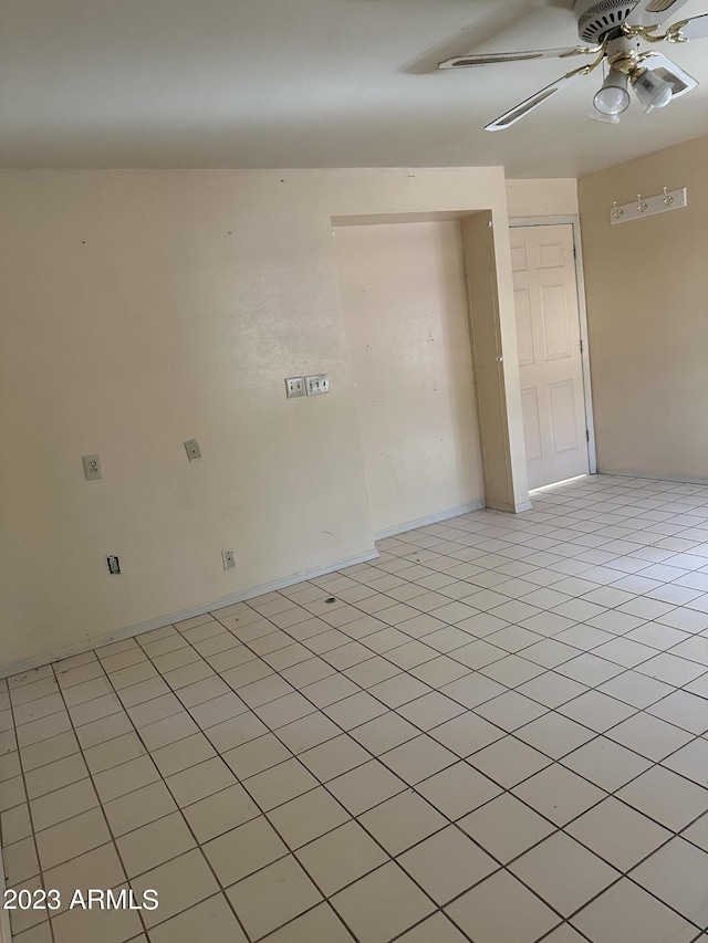 tiled spare room with ceiling fan