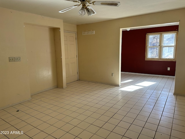 tiled spare room featuring ceiling fan