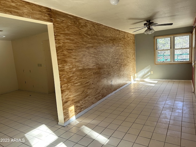 empty room with light tile floors and ceiling fan